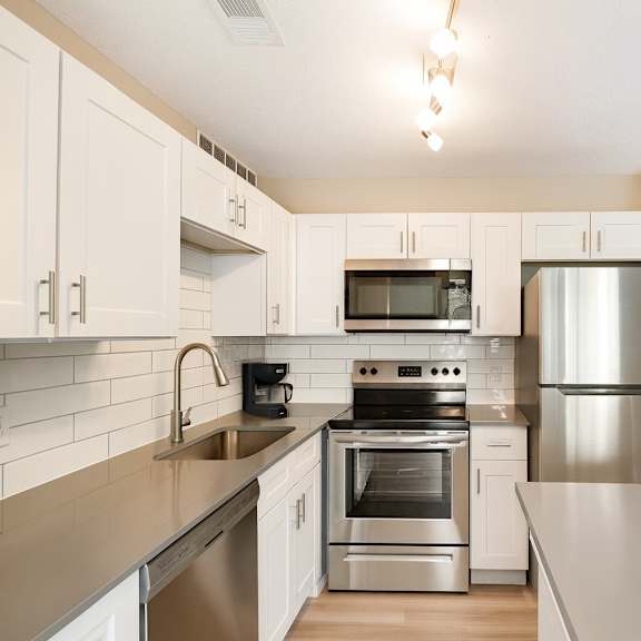 A modern kitchen with stainless steel appliances and white cabinets.