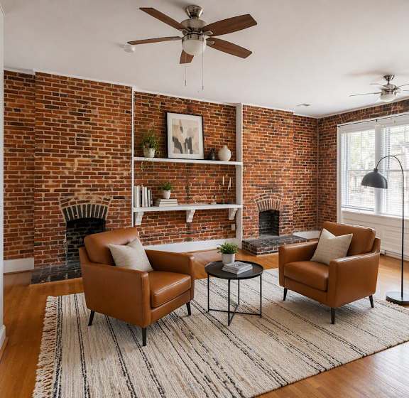 A room with wooden floors and a brick wall.