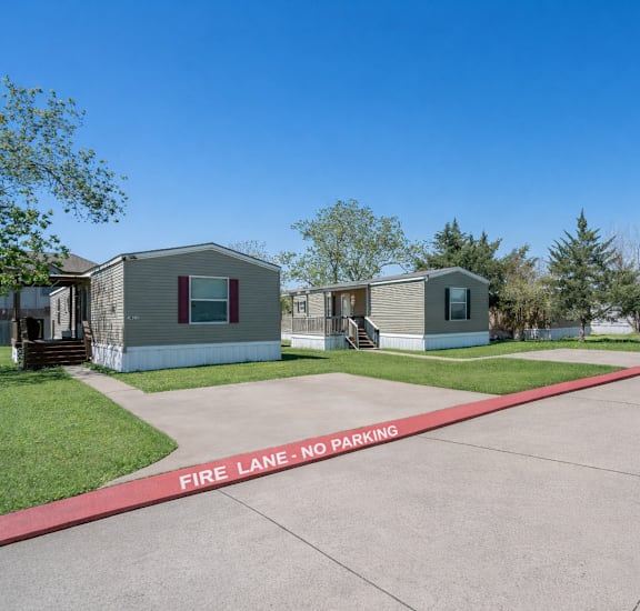 A row of houses with a red line in the middle of the image that says Fire Lane - No Parking.