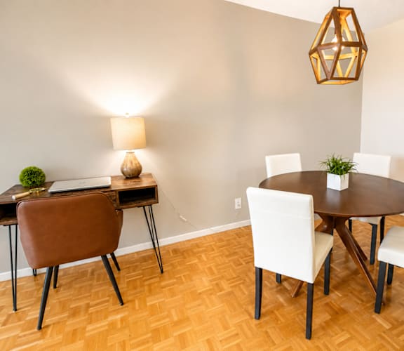 A dining room with a round table and chairs.