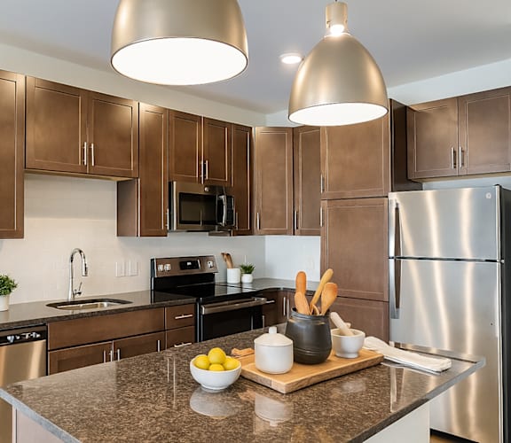 A kitchen with brown cabinets and a granite countertop.