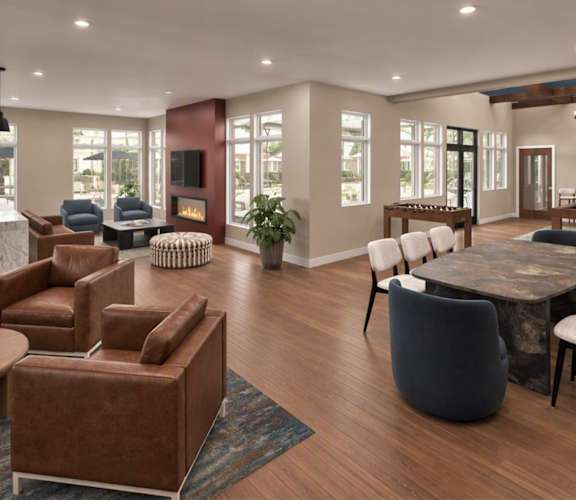 A living room with brown leather furniture and a fireplace.