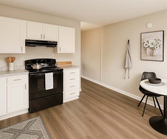 A modern kitchen with a black stove top oven and white cabinets.