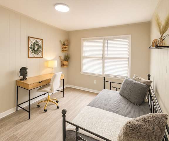 A bedroom with a bed, desk, and chair.