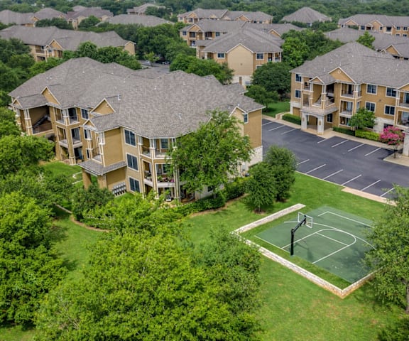 A tennis court is located in the middle of apartment buildings.