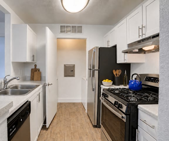 A kitchen with black appliances and white cabinets.