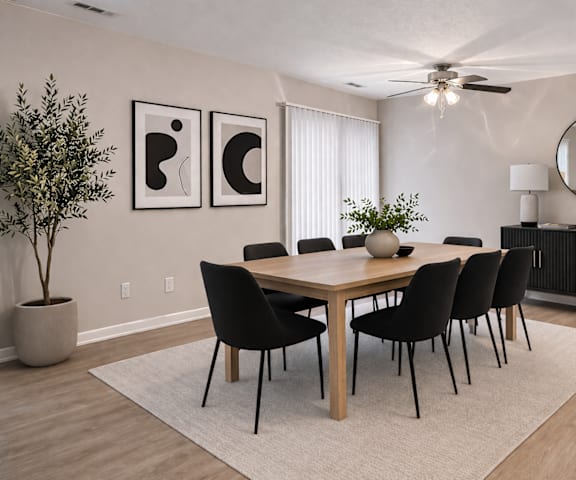 A dining room with a table, chairs, and a ceiling fan.