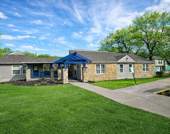 A house with a blue roof and a stone wall.