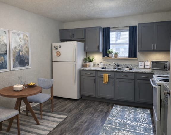 A kitchen with a refrigerator, table, and chairs.