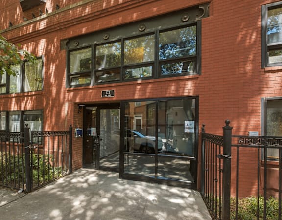 A red brick building with a black gate in front.