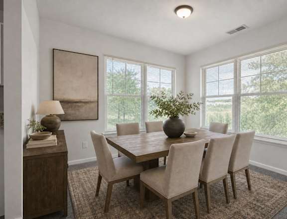 A dining room with a table and chairs.