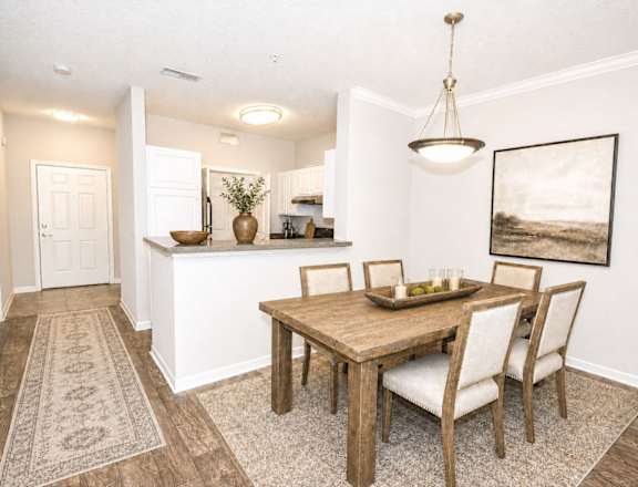 A dining room with a wooden table and chairs.