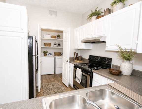 A kitchen with white cabinets and a black stove top oven.