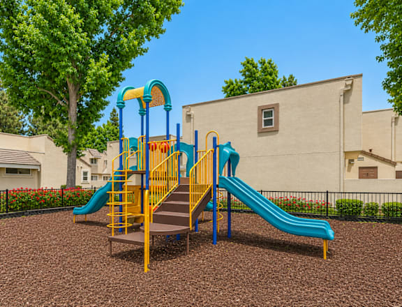 A playground with a blue and yellow slide.