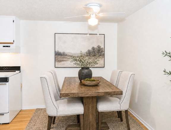 A dining room with a wooden table and chairs.