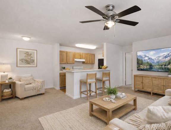 A living room with a ceiling fan and a painting of a mountain landscape on the wall.