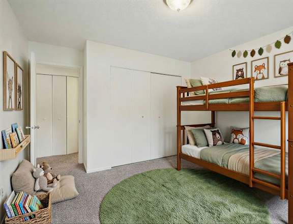 A bedroom with a bed, two nightstands, and a ceiling fan.