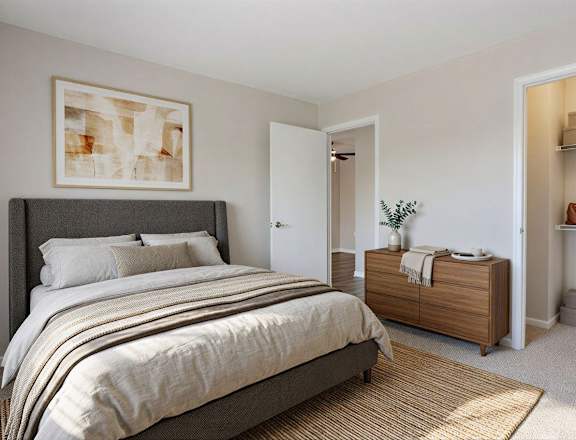 A bedroom with a large bed, a nightstand, and a TV on a cabinet.