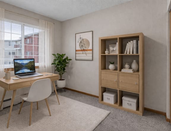 A room with a desk, chair, and a plant.