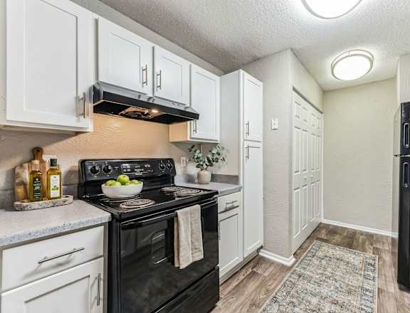 A kitchen with wooden cabinets and a black oven.