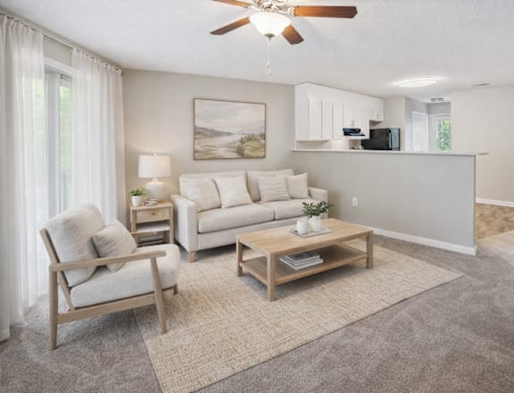 A living room with a ceiling fan and a painting on the wall.