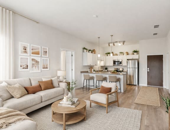 A modern living room with a white couch, wooden coffee table, and a kitchen in the background.