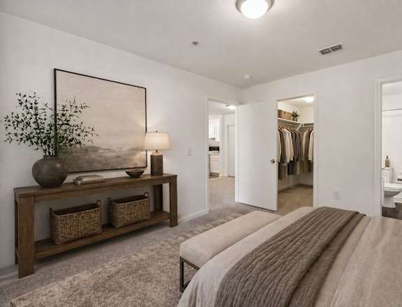 A bedroom with a large bed and a painting on the wall.