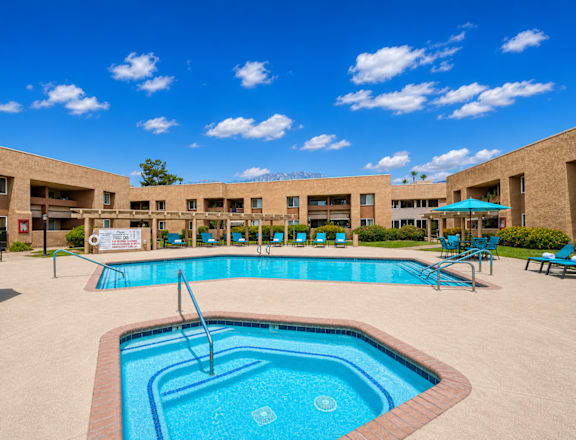 A large outdoor swimming pool with a fountain in the middle.