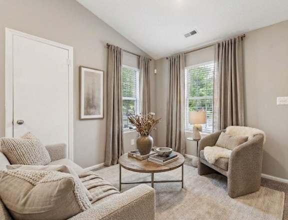 A living room with a white couch, a wooden coffee table, and a ceiling fan.