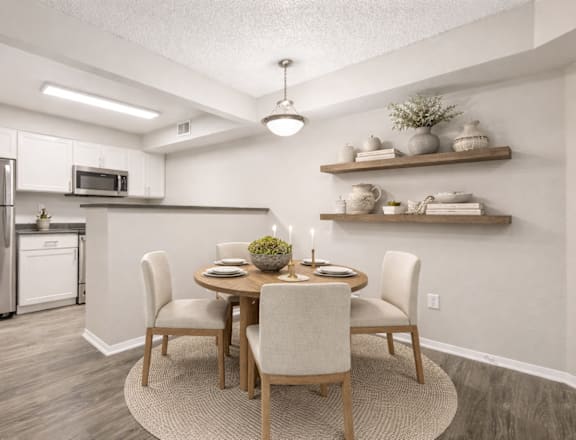 A modern kitchen with a dining table set for two.