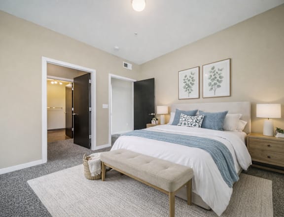 A bedroom with a bed, nightstand, and a rug.