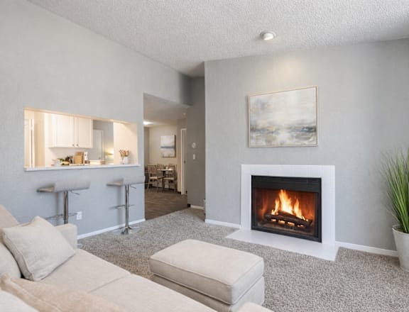 A living room with a fireplace and a painting on the wall.