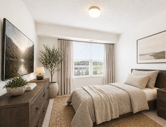 A well-lit bedroom with a large bed, a nightstand, and a dresser.