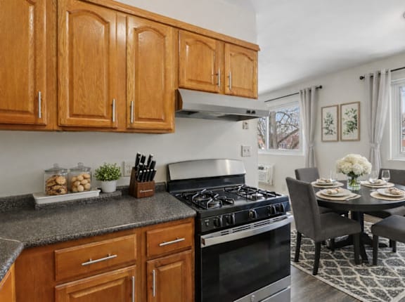 A kitchen with wooden cabinets and a black stove top oven.