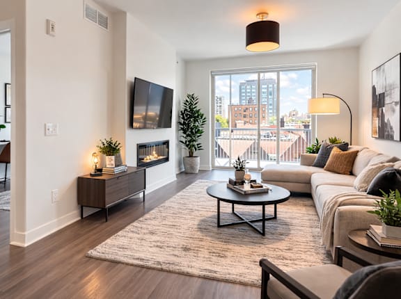 A living room with a couch, coffee table, and a flat screen TV.