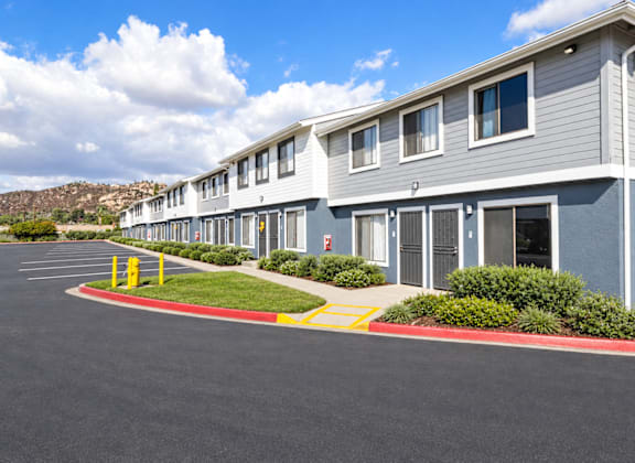 A row of grey houses with a red and yellow striped curb in front.