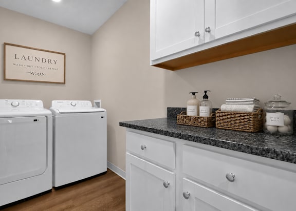 A laundry room with two washing machines and a counter with baskets on it.