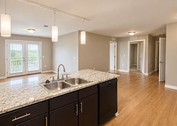 A blue and white townhouse with a front yard and a driveway.at Hawthorne Pointe, Bondurant, 50035