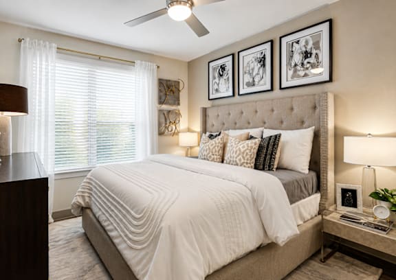 A bedroom with a large bed and a ceiling fan.