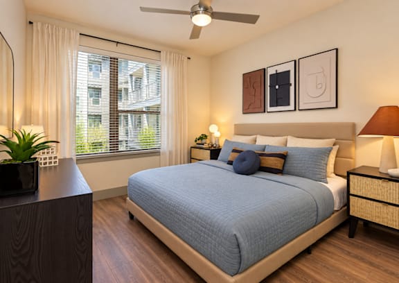 A bedroom with a large bed and a ceiling fan.