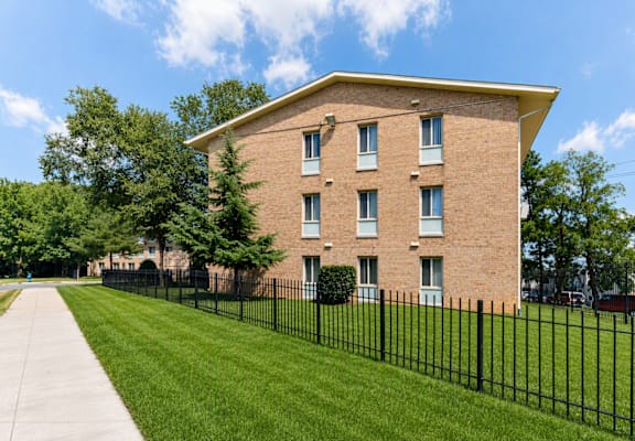 A brick building with a black fence in front.