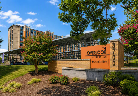 A building with a sign that reads "Overlook" is surrounded by trees and shrubs.