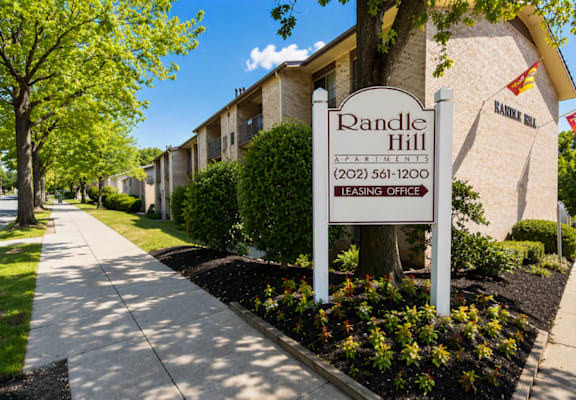 A sign for Randle Hill Apartments stands in front of apartment buildings.