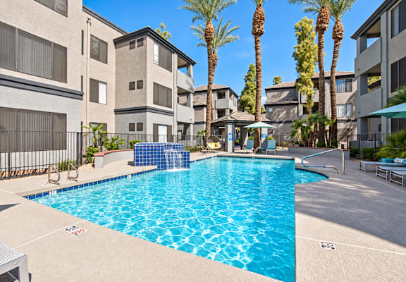 A swimming pool in front of apartment buildings.