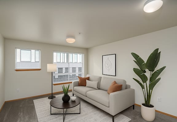 A living room with a couch, a coffee table, and a plant.