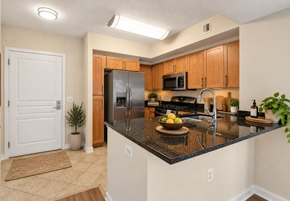 A kitchen with a black countertop and wooden cabinets.