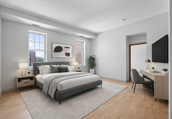 A modern bedroom with a large bed, a desk, and a chair.