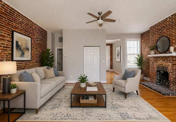 A living room with a brick wall and a fireplace.