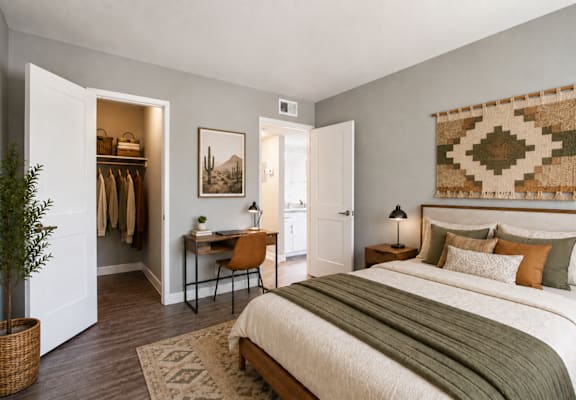 A bedroom with a large bed and a woven wall hanging.