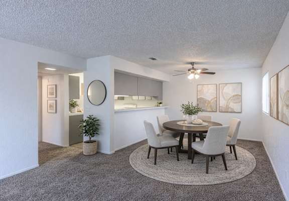 A dining room with a round table and chairs.